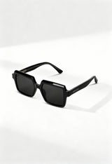LatenzaZero Echelon unisex sunglasses with black acetate frame and square UV3 lenses, displayed on a white surface under natural light.