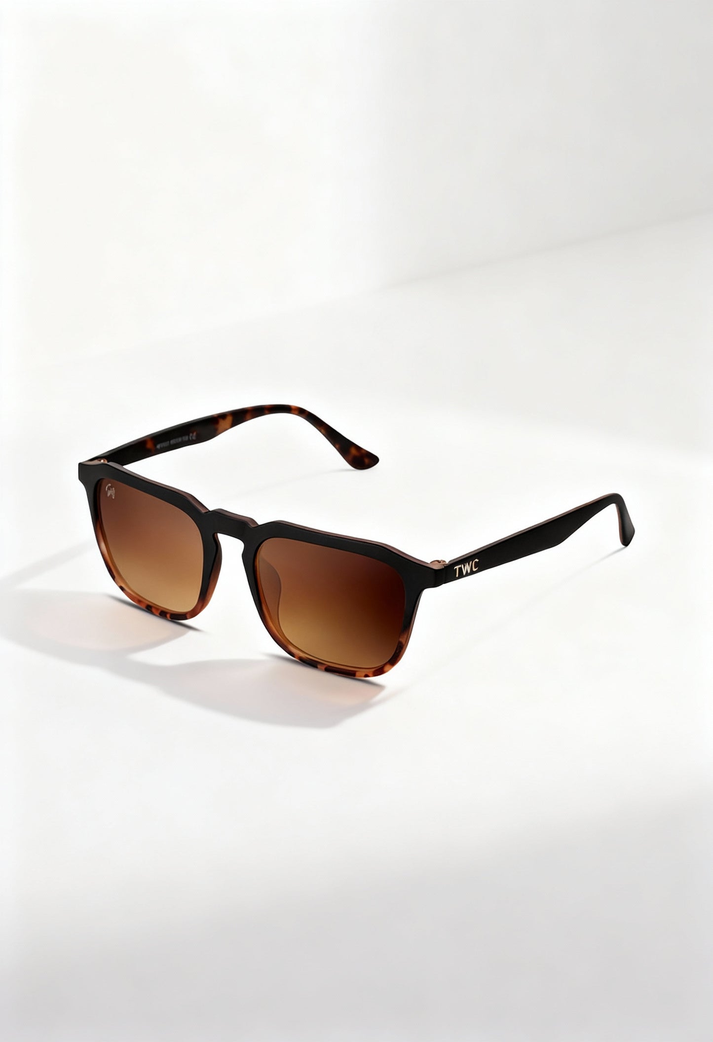 Twig Roth unisex square sunglasses in black frame with brown gradient UV3 lenses, displayed on a white surface under natural light.