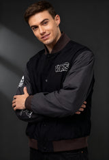 Male model wearing Vans VN000JY1KOU1 black bomber jacket with grey sleeves and visible chest logo.