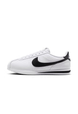 Side profile of authentic white Nike Cortez shoes highlighting the retro silhouette.