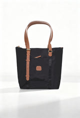 Front studio shot of the Bric’s BXG05070-1906604 black nylon shopping bag with brown leather handles.