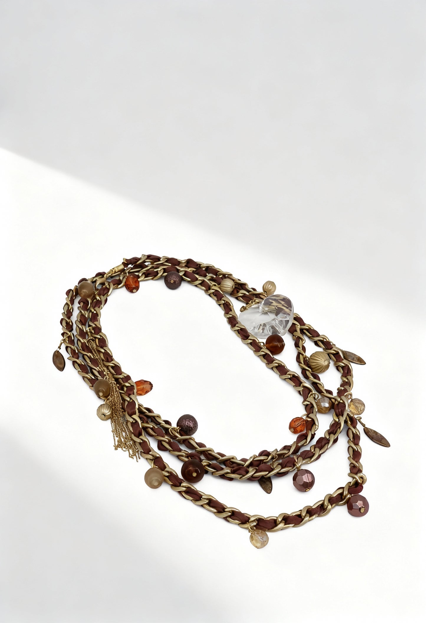 Authentic Guess UF306200 women's 175cm stainless steel multi-strand necklace featuring bronze-tone braided chains, decorative appliques, and crystal charms.