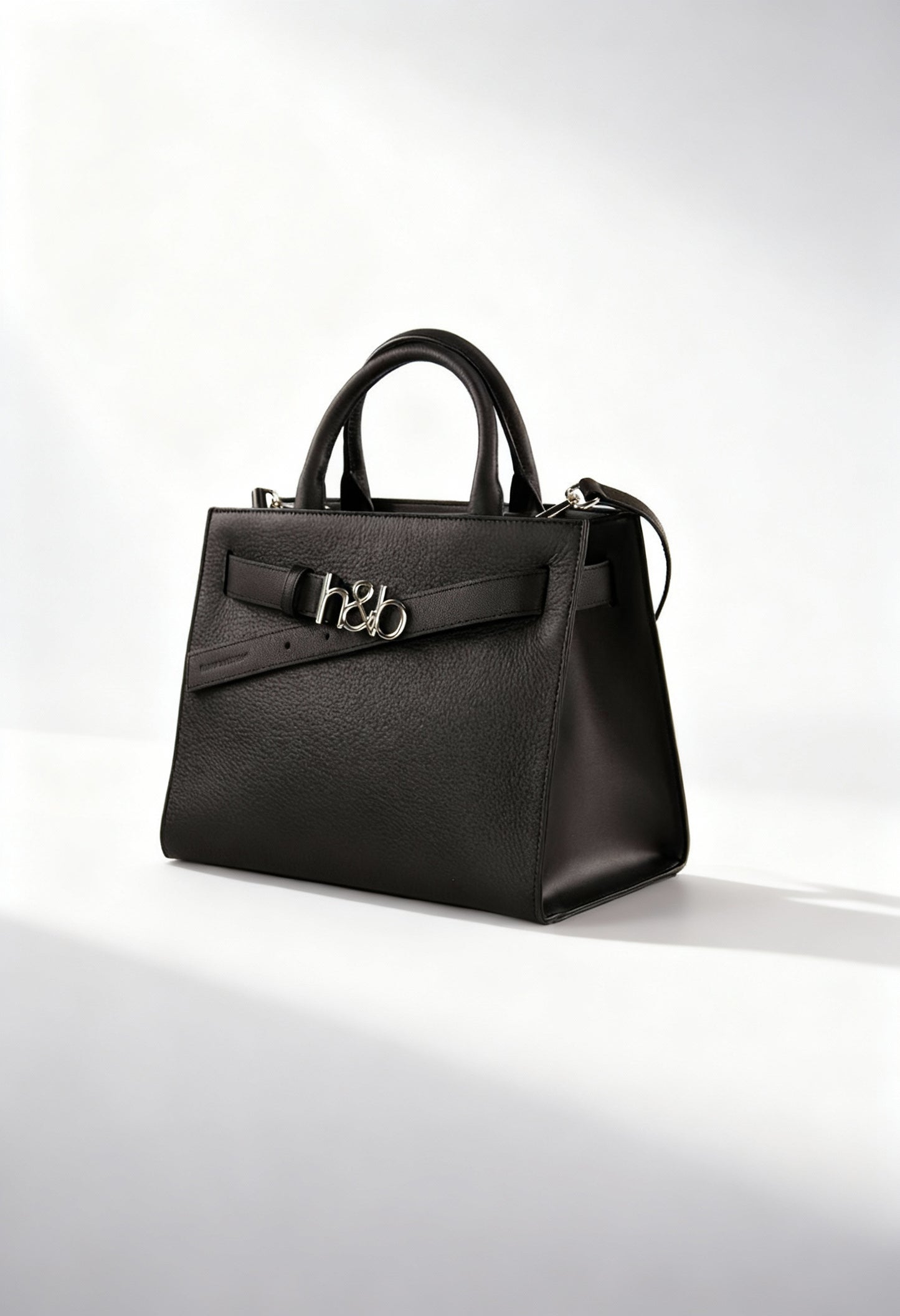 Front angled studio shot of the Harmont&Blaine H4DPWH510042 black structured handbag with metal logo detail.