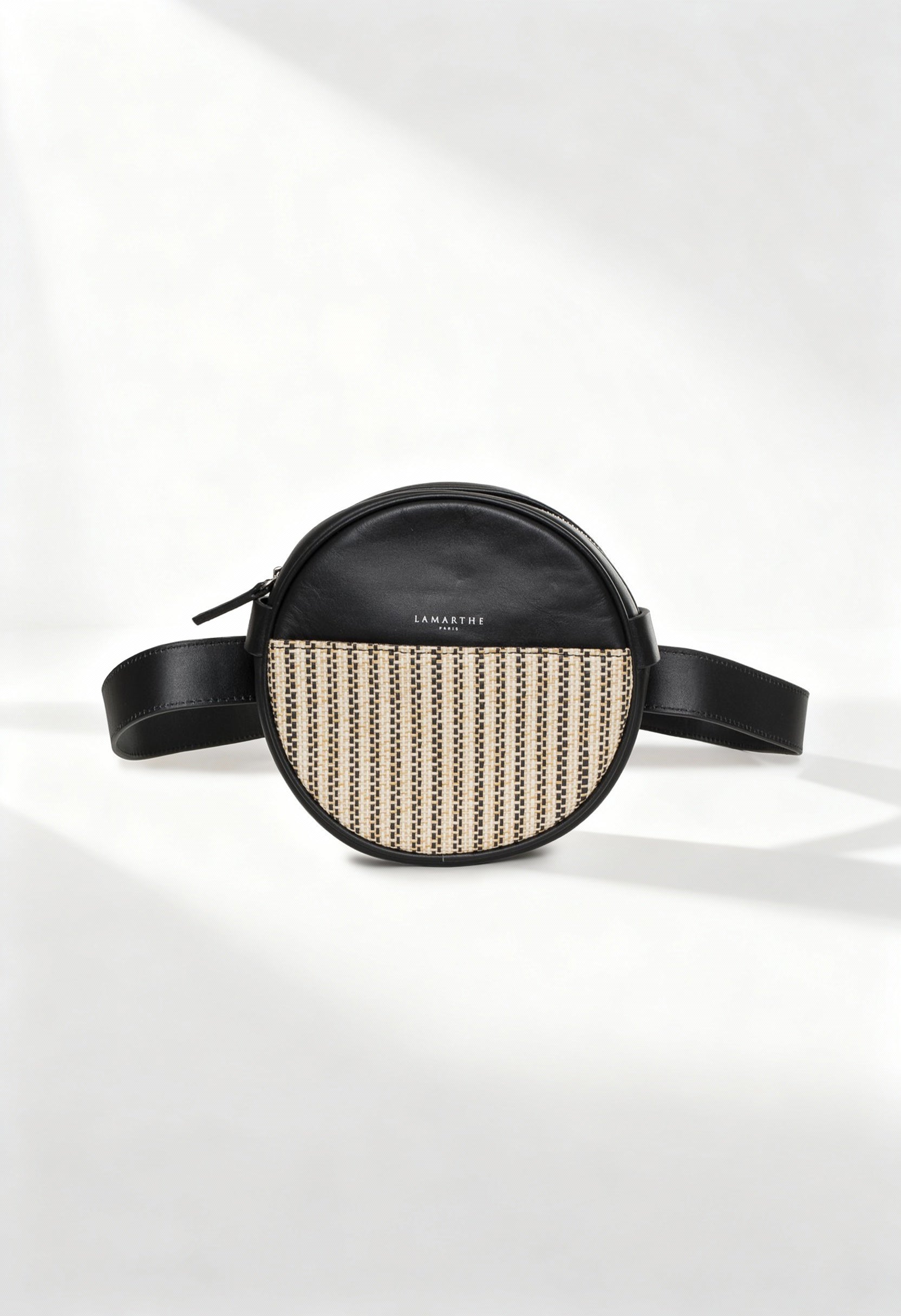 Front view of the Lamarthe PR176 black leather round crossbody bag with beige patterned front panel.