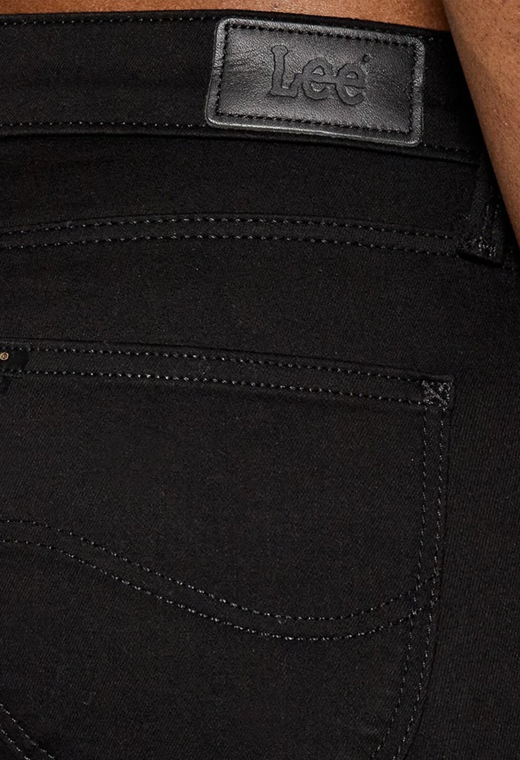 Close-up detail of the stitching and Lee logo patch on the black L526FS47 skinny jeans.