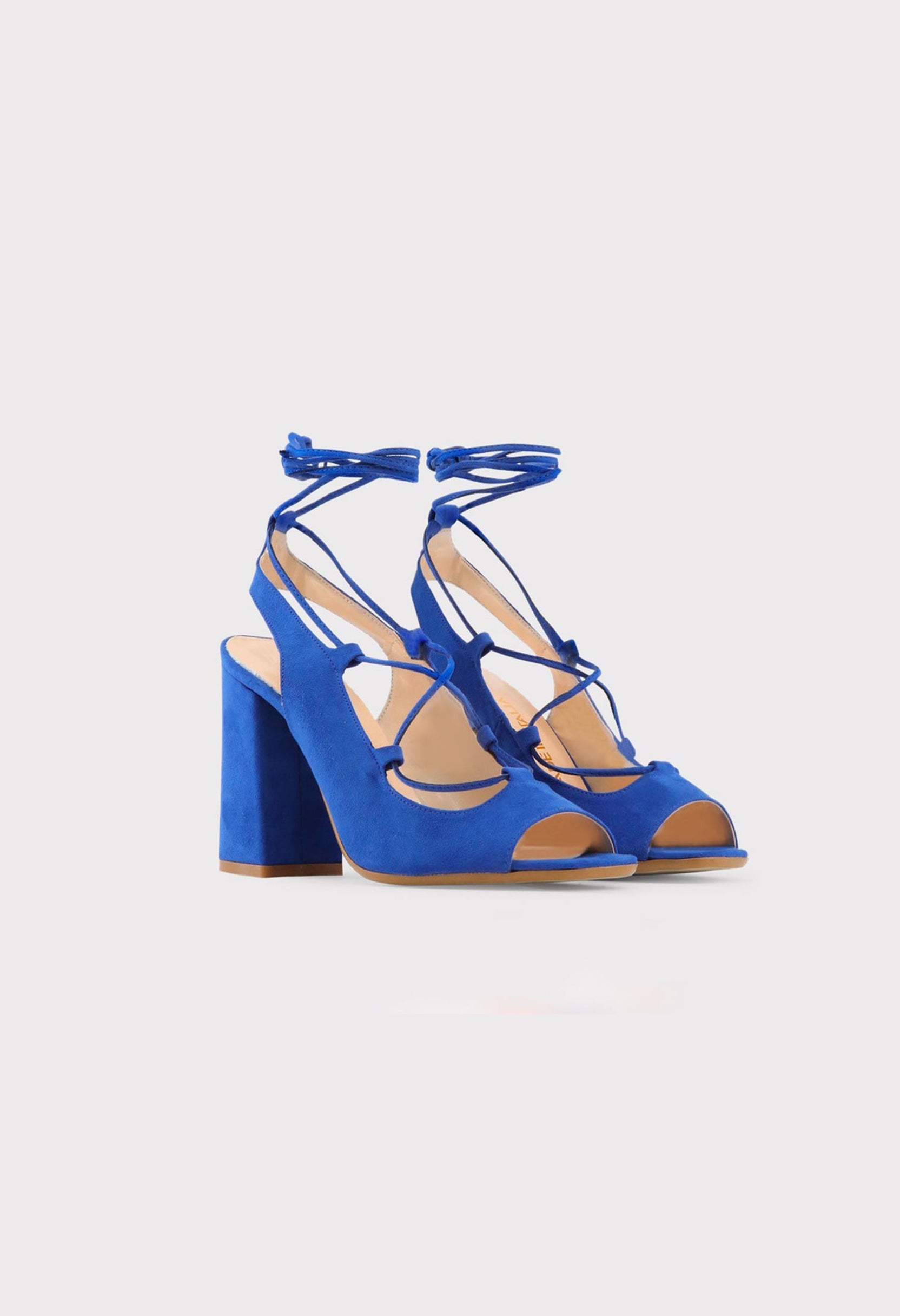 Three-quarter angle of the blue variation of LINDA lace-up block heel sandals highlighting the wrap-around straps.