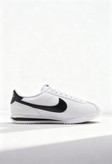 Brand new Nike Cortez men's sneakers in white leather with black Swoosh side view.
