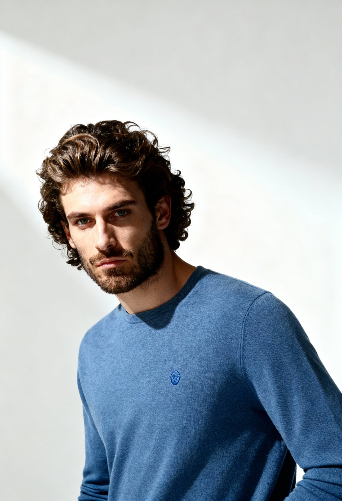 Sergio Tacchini men's 100% wool sweater in blue, worn by model, showing round neckline.