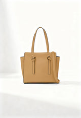 Front angle of the beige Twig Debussy shoulder bag with structured silhouette and knot detailing.