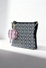 Front angled view of the Valentino TONIC-VBS69906 patterned crossbody bag with pink round coin pouch.