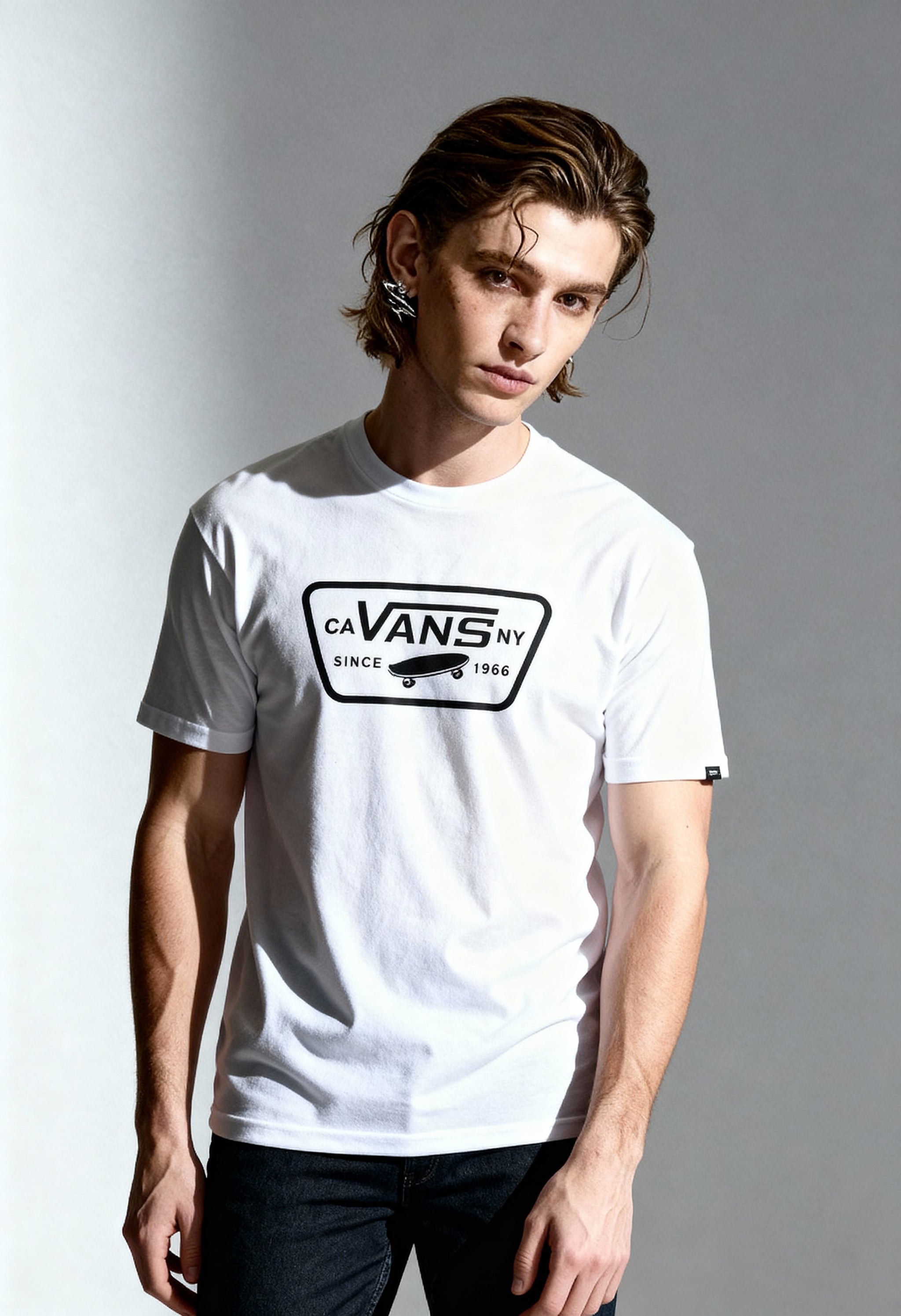 Front angled view of a man wearing the white Vans VN000QN8YB21 T-shirt on a light background.